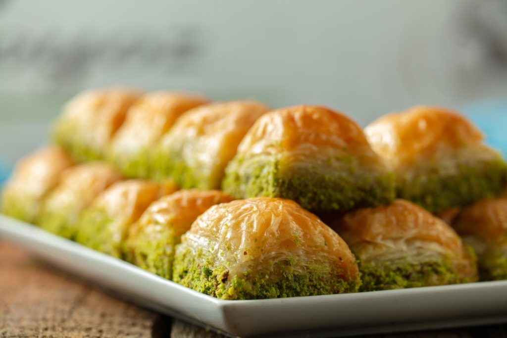 Closeup of baklava with pistachio cut in cubes under the lights with a blurry background