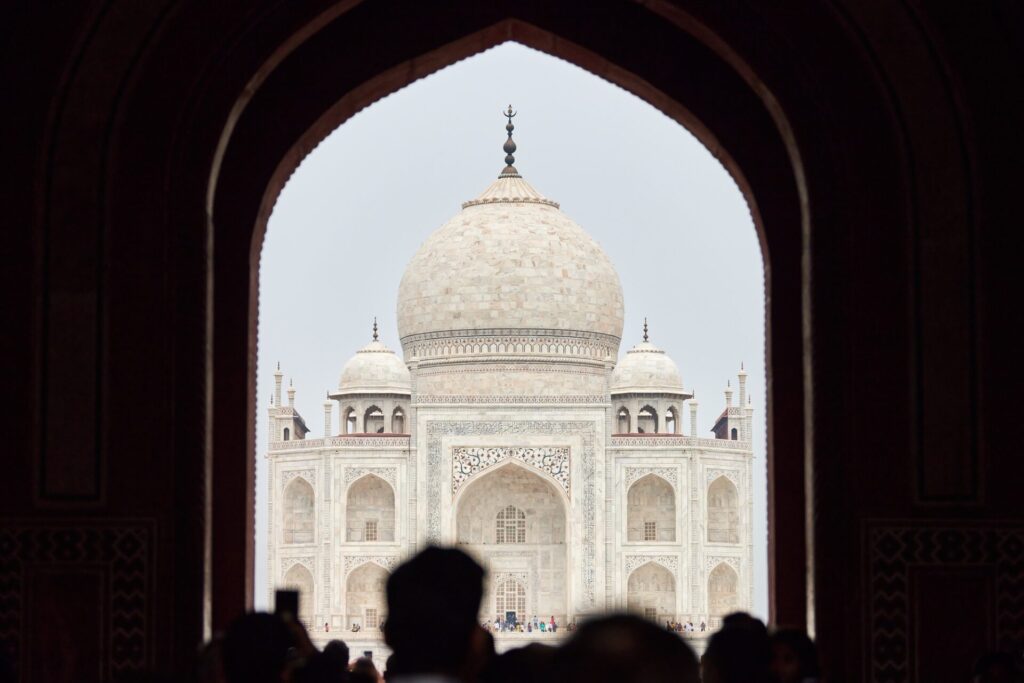 Qué ver en Agra y el Taj Mahal  Archway of main gateway in Taj Mahal entrance with tourists silhouettes, view to Taj Mahal mausoleum