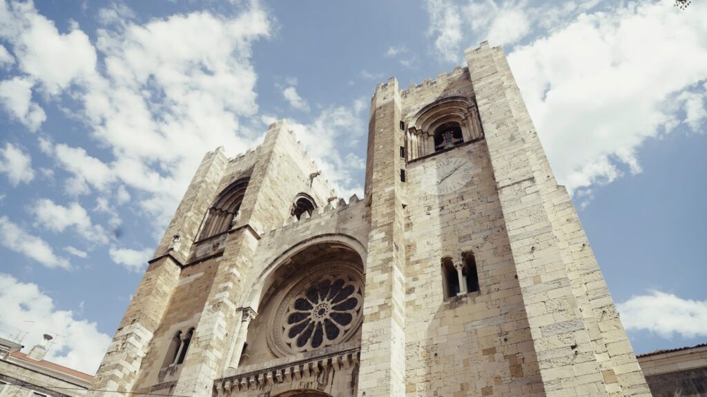 Lisbon Cathedral on a summer day. Action. Low angle view of beautiful ancient building on a blue Qué ver en Lisboa en 3 días.