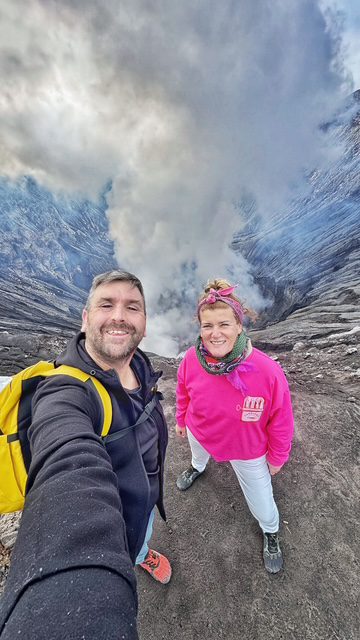 Pareja se toma selfie al borde de cráter de volcán en Malang, ejemplo de destinos exóticos baratos