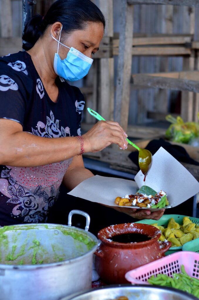 a woman wearing blue face mask serving food