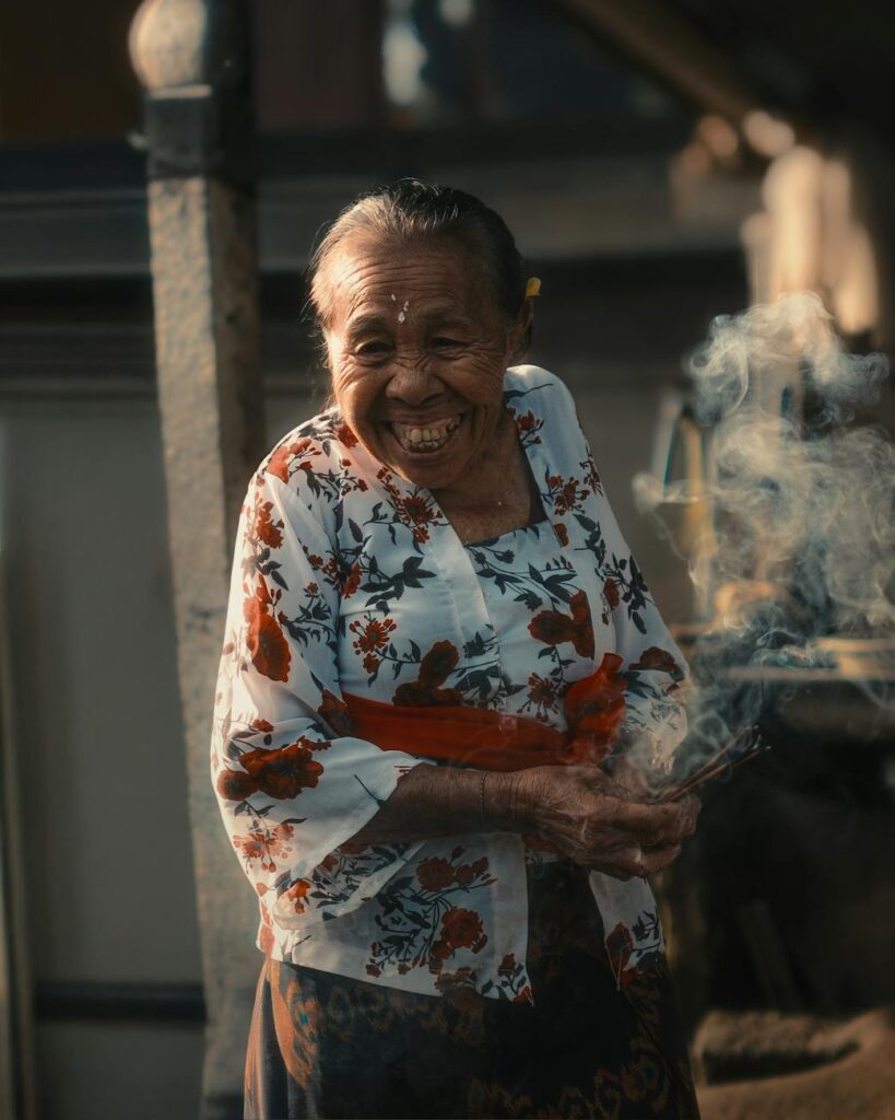 elderly woman smiling at traditional temple in bali