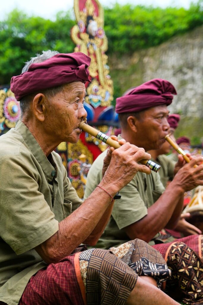 traditional balinese musicians playing bamboo flutes