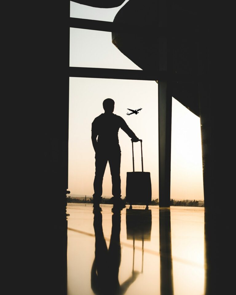 Hombre mirando a un avión desde un aeropuerto junto a su maleta